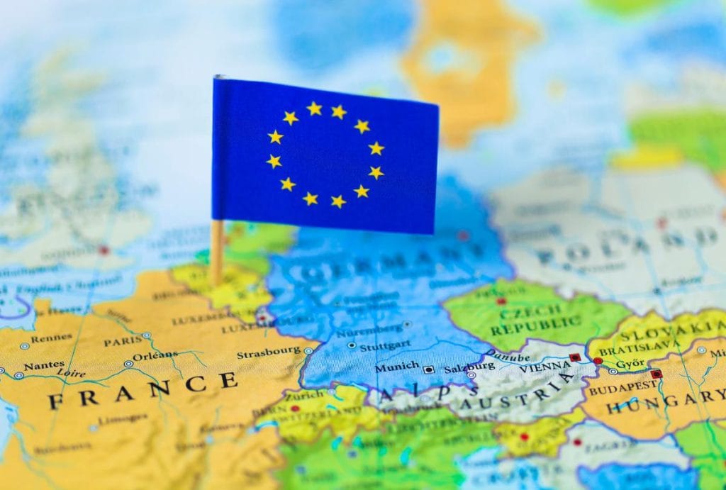 A closeup of a map with an EU flag is the featured image for this article about Baby carrier and sling standards in Europe