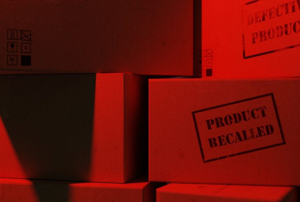 childresns product recalls illustrated by a stack of boxes in red light that say "product recall"