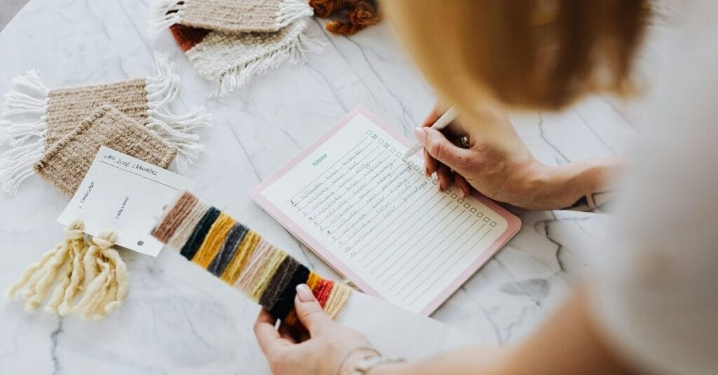 This article about EU compliance for baby slings and carriers is illustrated by someone holding a fabric swatch while checking off a handwritten list on a clipboard.